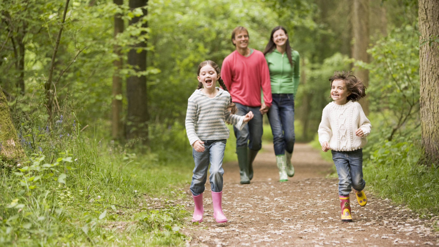 family walking in woodland - new homes in hamilton area